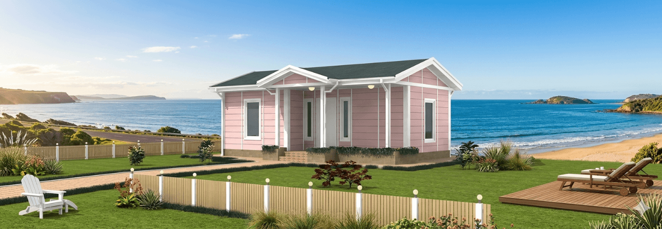 Deniz manzaralı bir araziye kurulmuş, modern mimariye sahip, pembe dış cephe panelleriyle dikkat çeken Alyans Prefabrik tek katlı modüler ev.