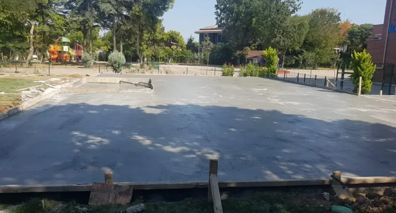 Prefabrik okul binası zemin beton dökümü ve modüler derslik kurulumu öncesi saha hazırlık süreci.